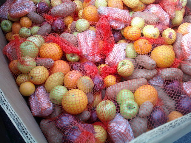 Mesh bags of produce in a cardboard container.
